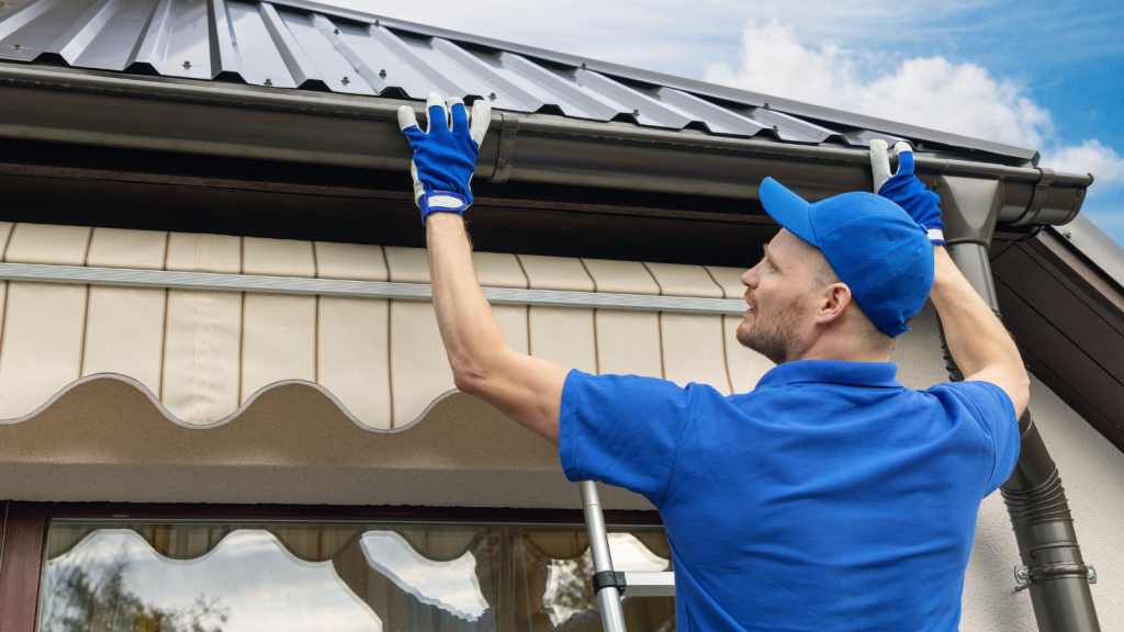 Person attaching a gutter to a roof