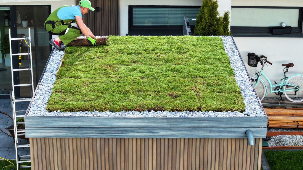 Person laying sod on top of roof