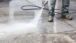 Power washing debris off a side walk